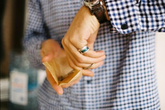 Man reaching in coinpurse to buy cannabis